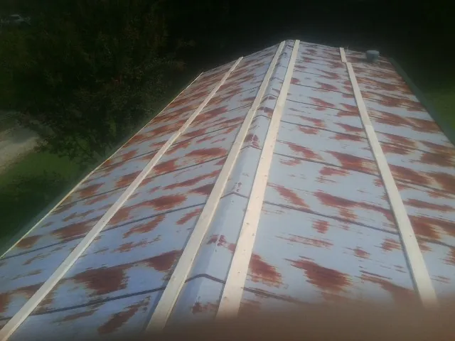 Rusted metal roof panels with new wood purlins before replacement — Storm Damage Roof Repair in Elkmont by Roofing Brothers