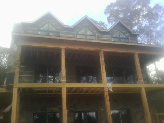 Dormers and porch framing on a large log home under construction — Roof Coating work by our crew in Elkmont