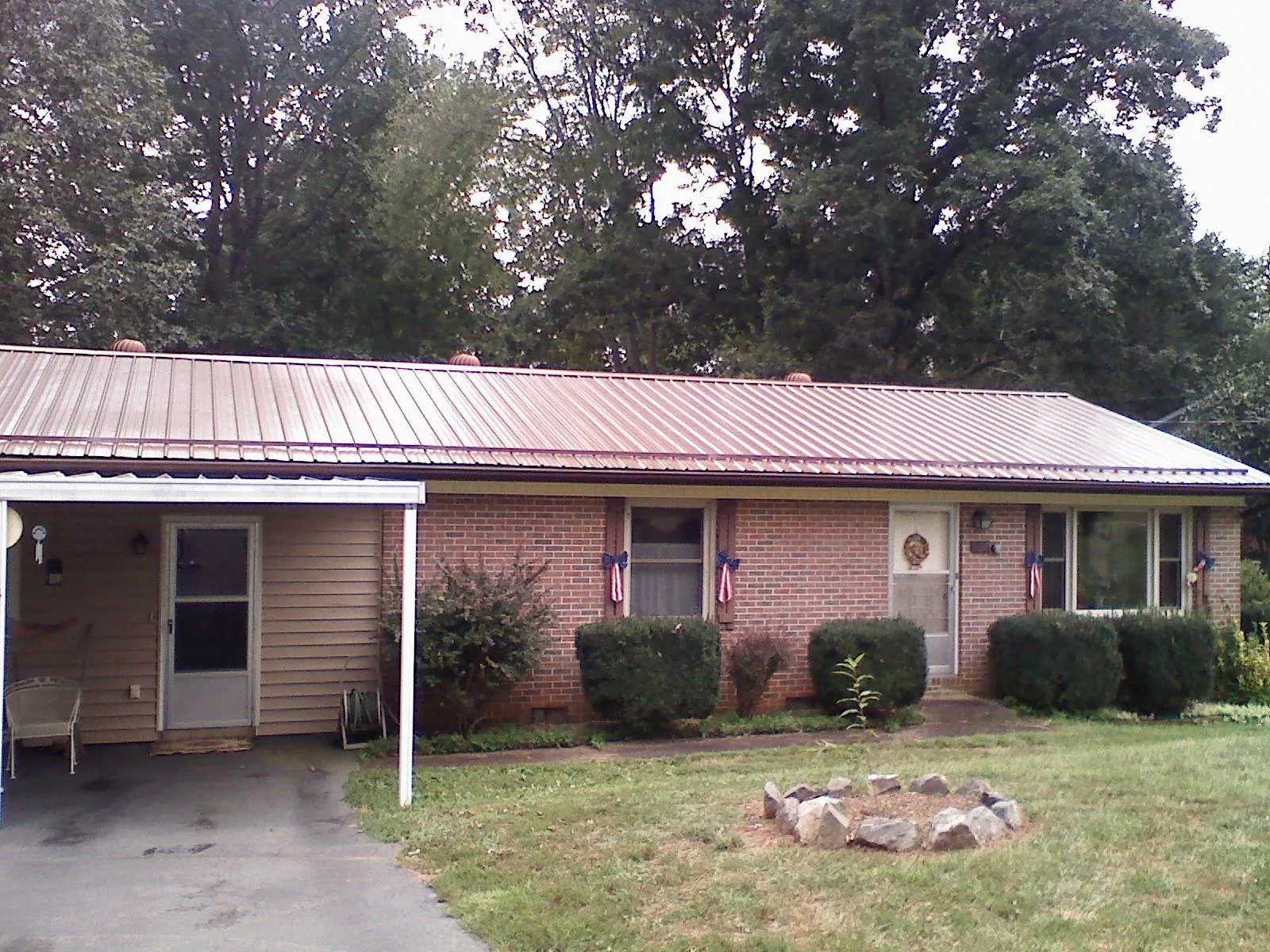 Bronze metal roof and carport on a brick ranch home — Roof Repair work by our crew in Elkmont